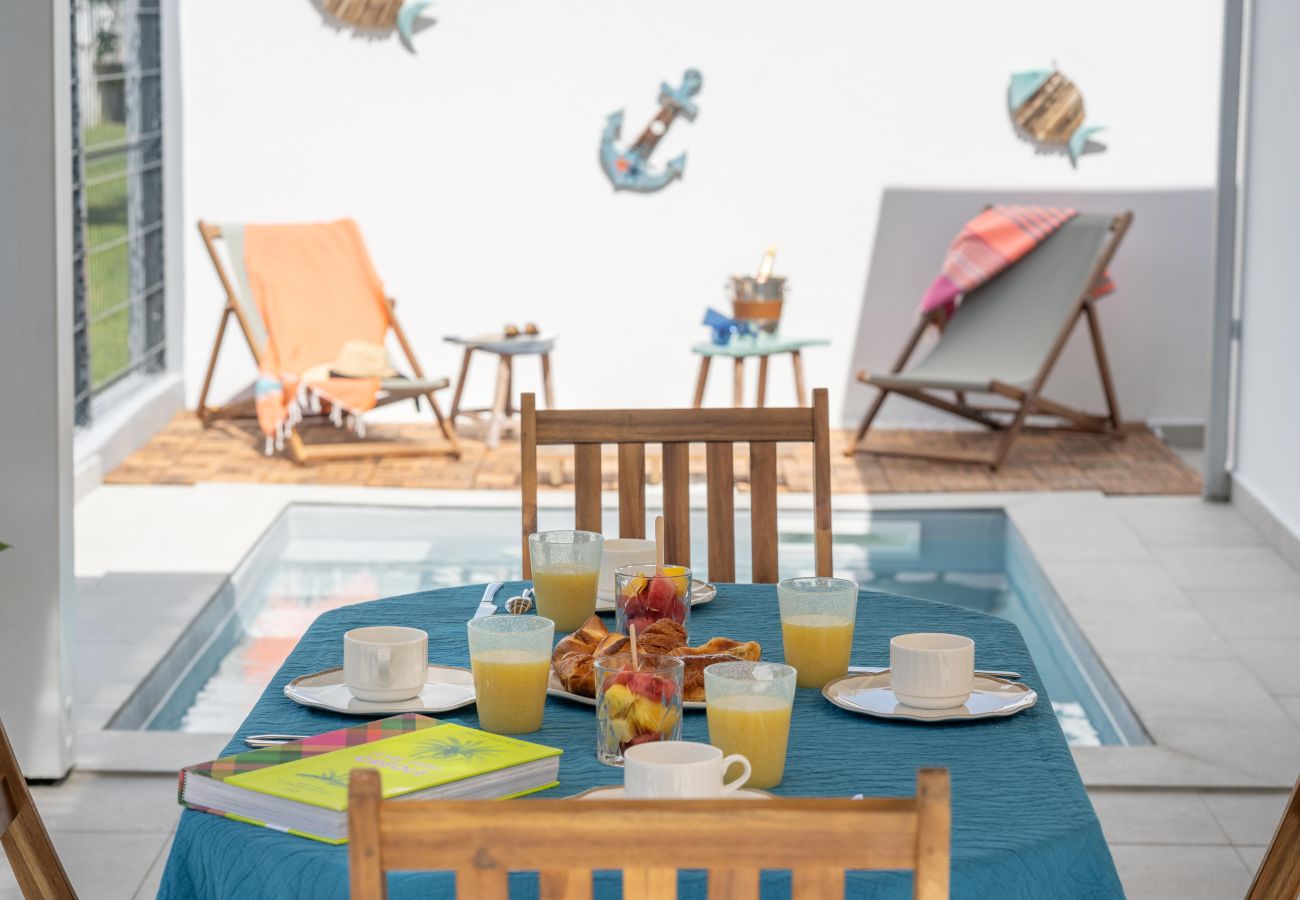 Photo d'extérieur montrant la piscine et les mobiliers de jardin par un temps ensoleillé 